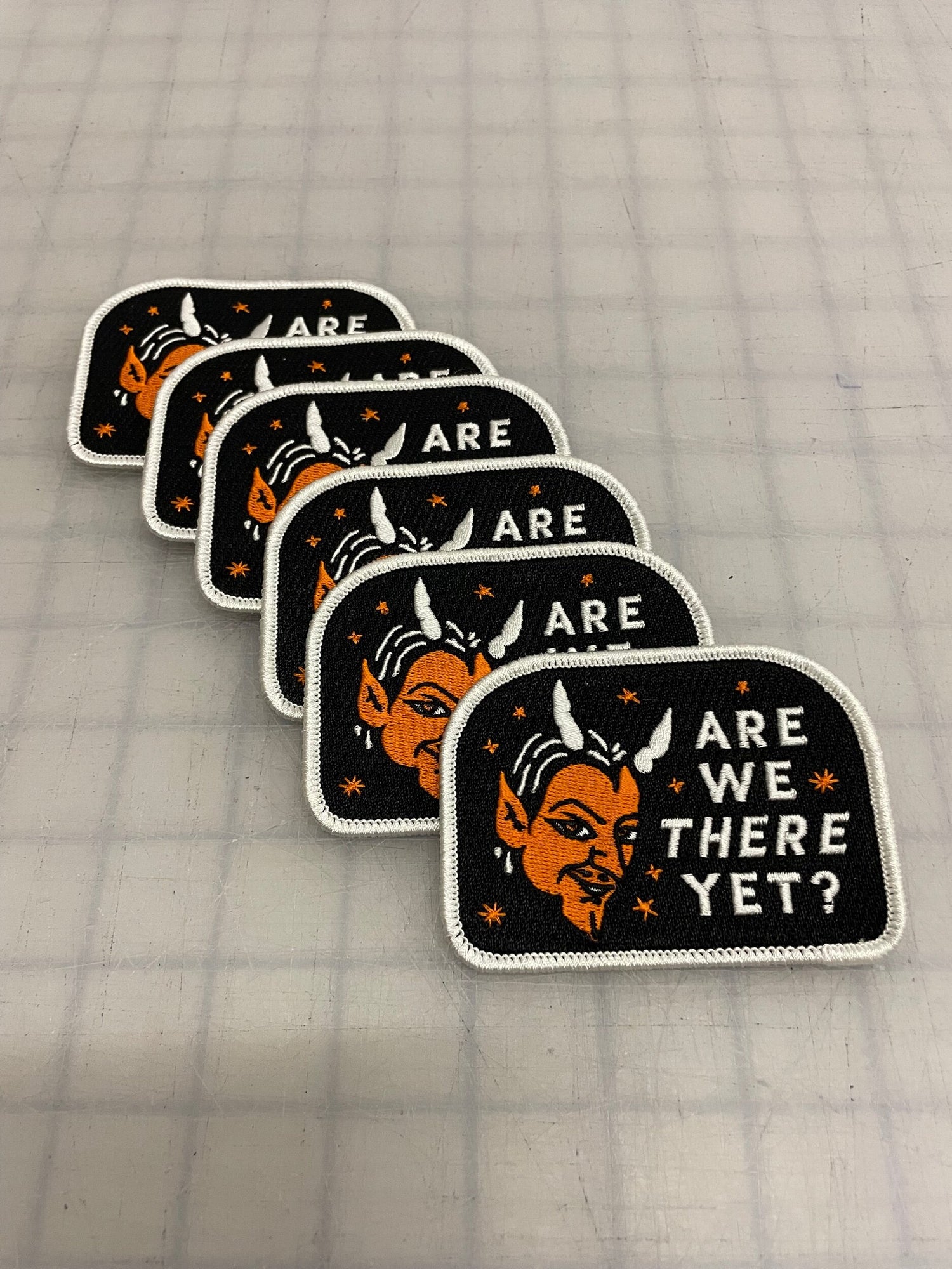 Black patch with a white edge with an orange devil that says