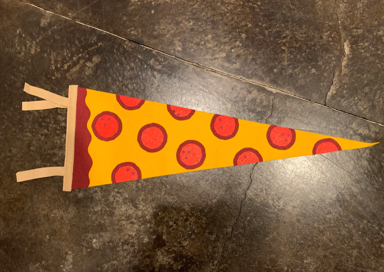 A pennant flag that looks like a slice of pepperoni pizza. 