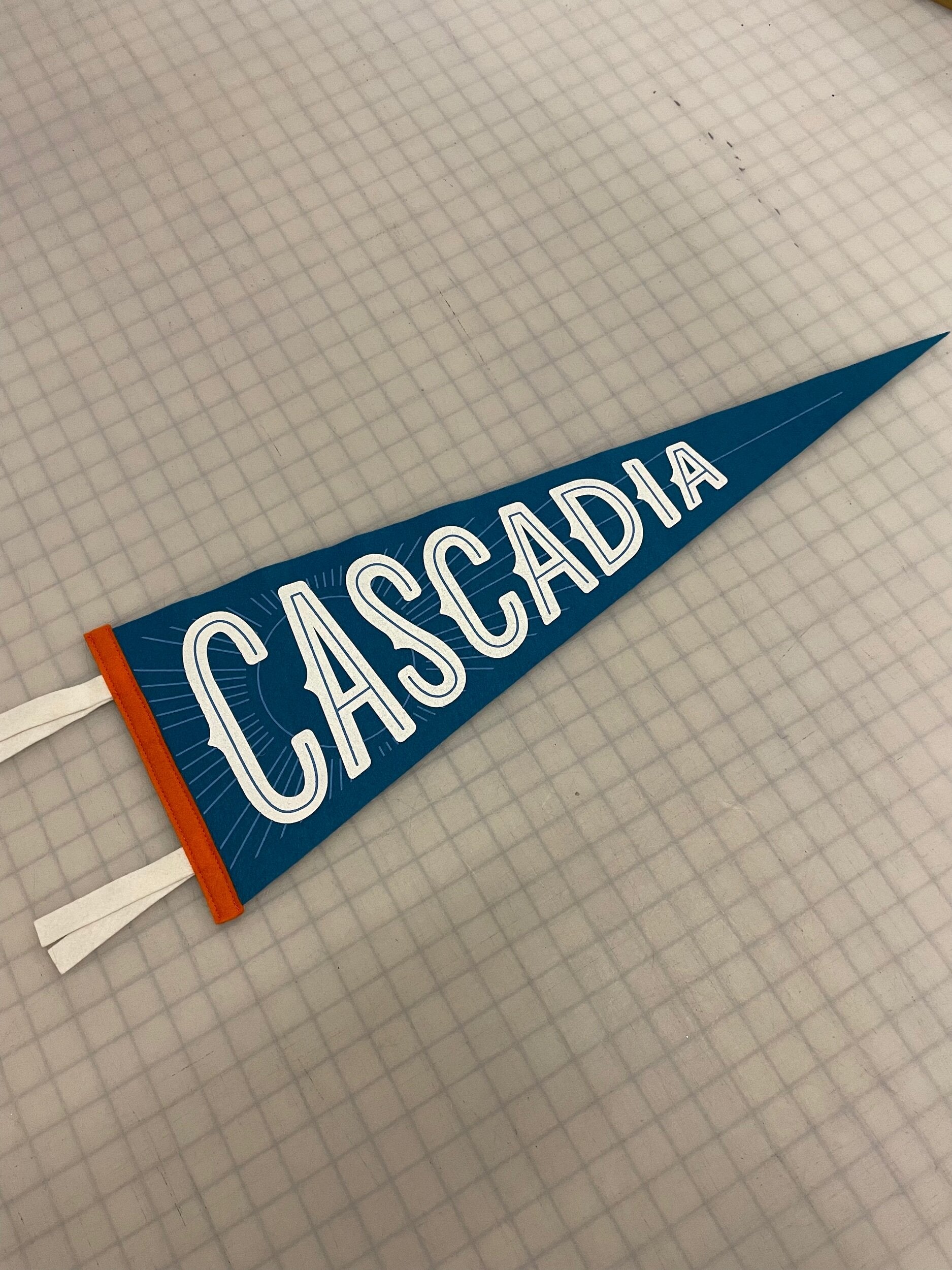 Dark Blue pennant flag that says "Cascadia" in white decorative letters
