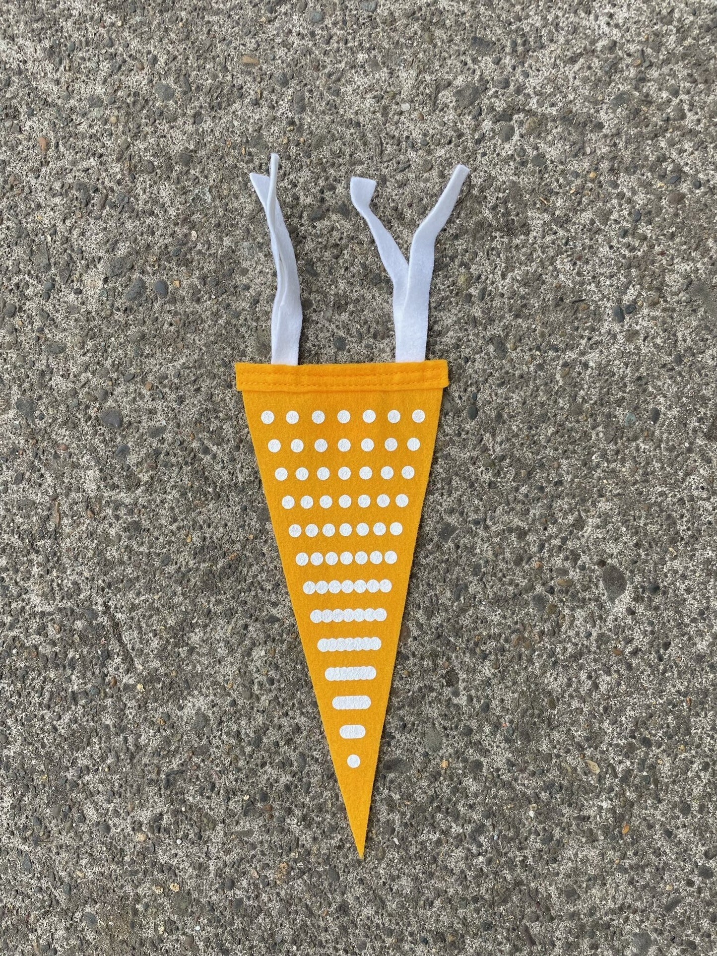 Yellow pennant flag with white dots making a ray pattern