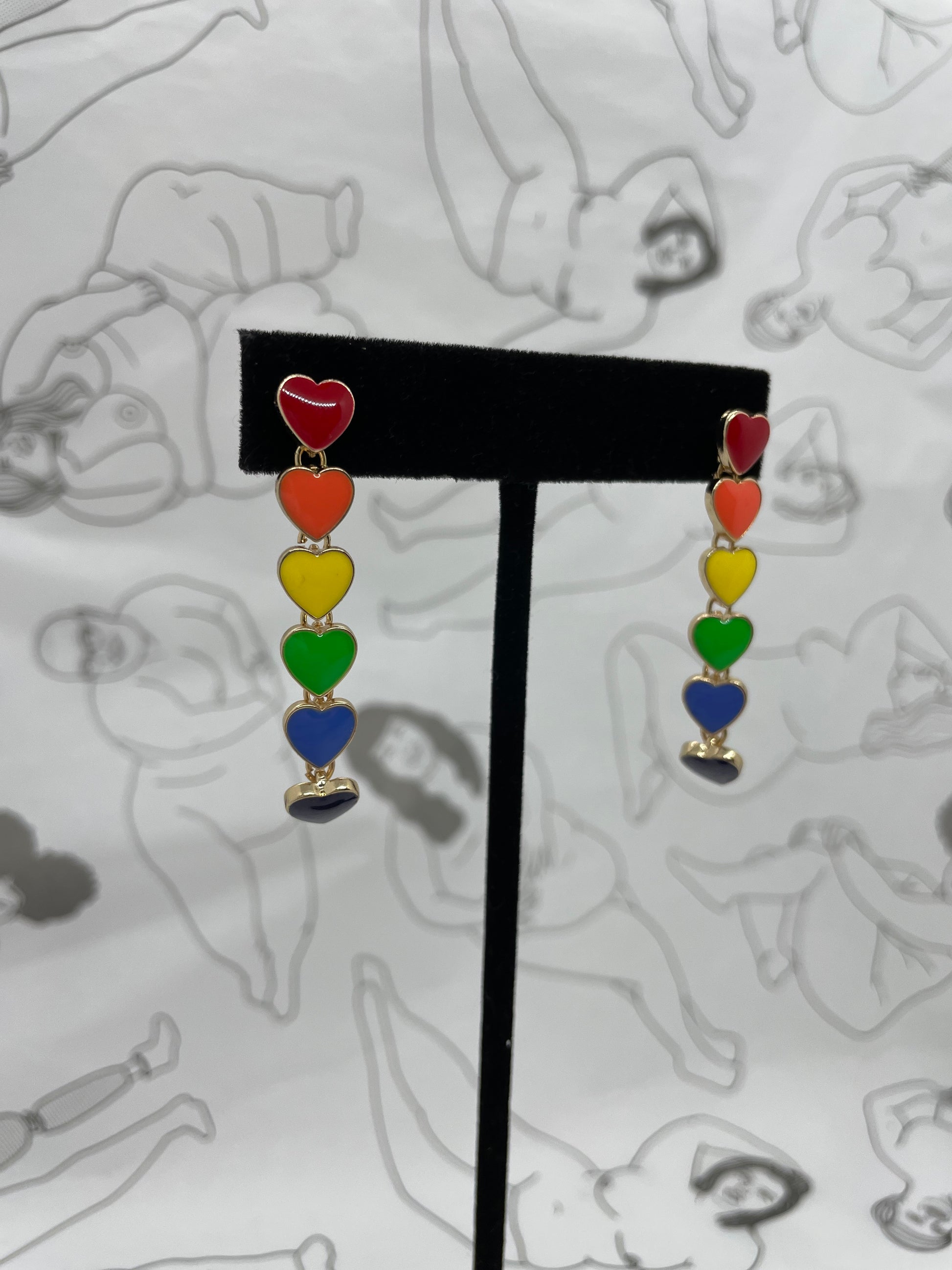 Post earrings with 6 hearts dangling in a line each one a color of the rainbow.