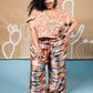  Full length wide leg pant with elastic waist in shiny orange, grey, and white modeled strips