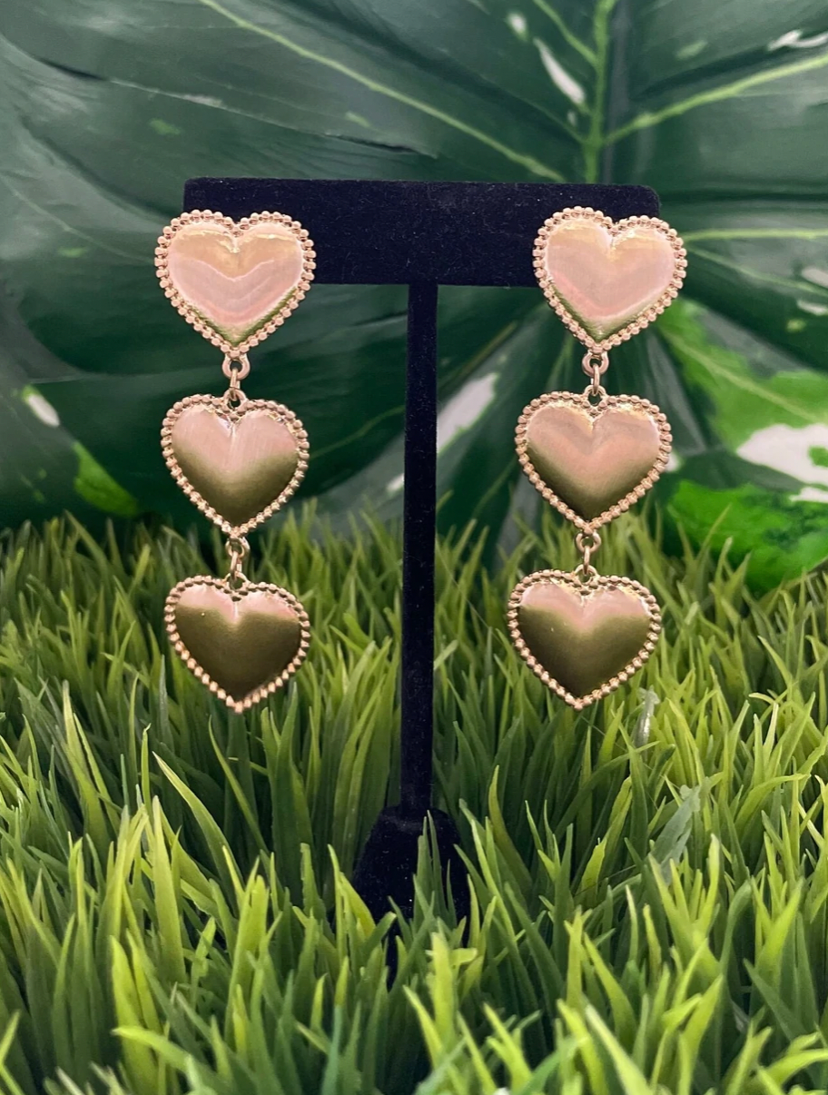 Gold heart dangly earrings with three hearts hanging in a line.