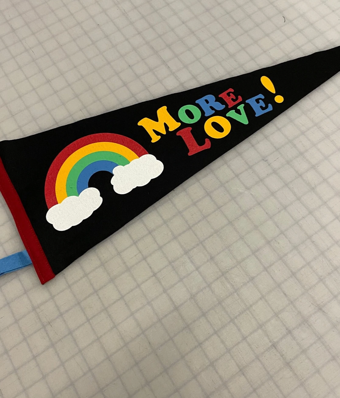 Black pennant flag with a rainbow that says 