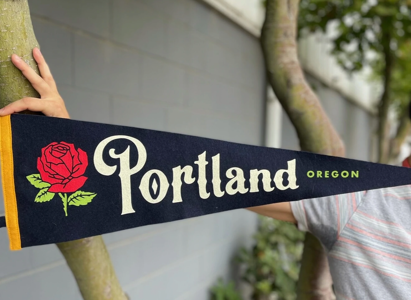 Navy blue pennant flag with a red rose that says 