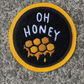 Black patch with yellow edge that says "Oh honey" in white letters with yellow honey comb underneath.