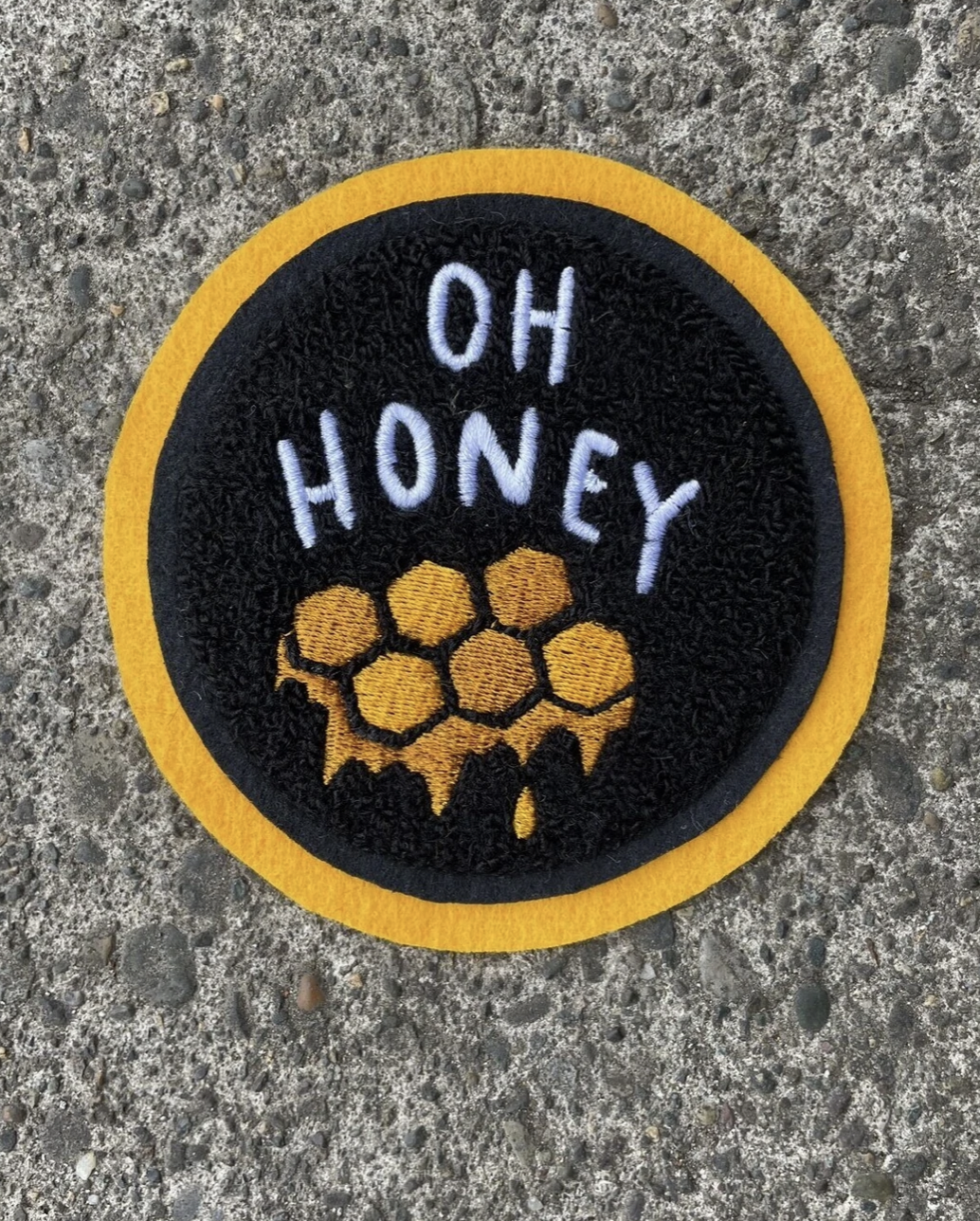 Black patch with yellow edge that says "Oh honey" in white letters with yellow honey comb underneath.
