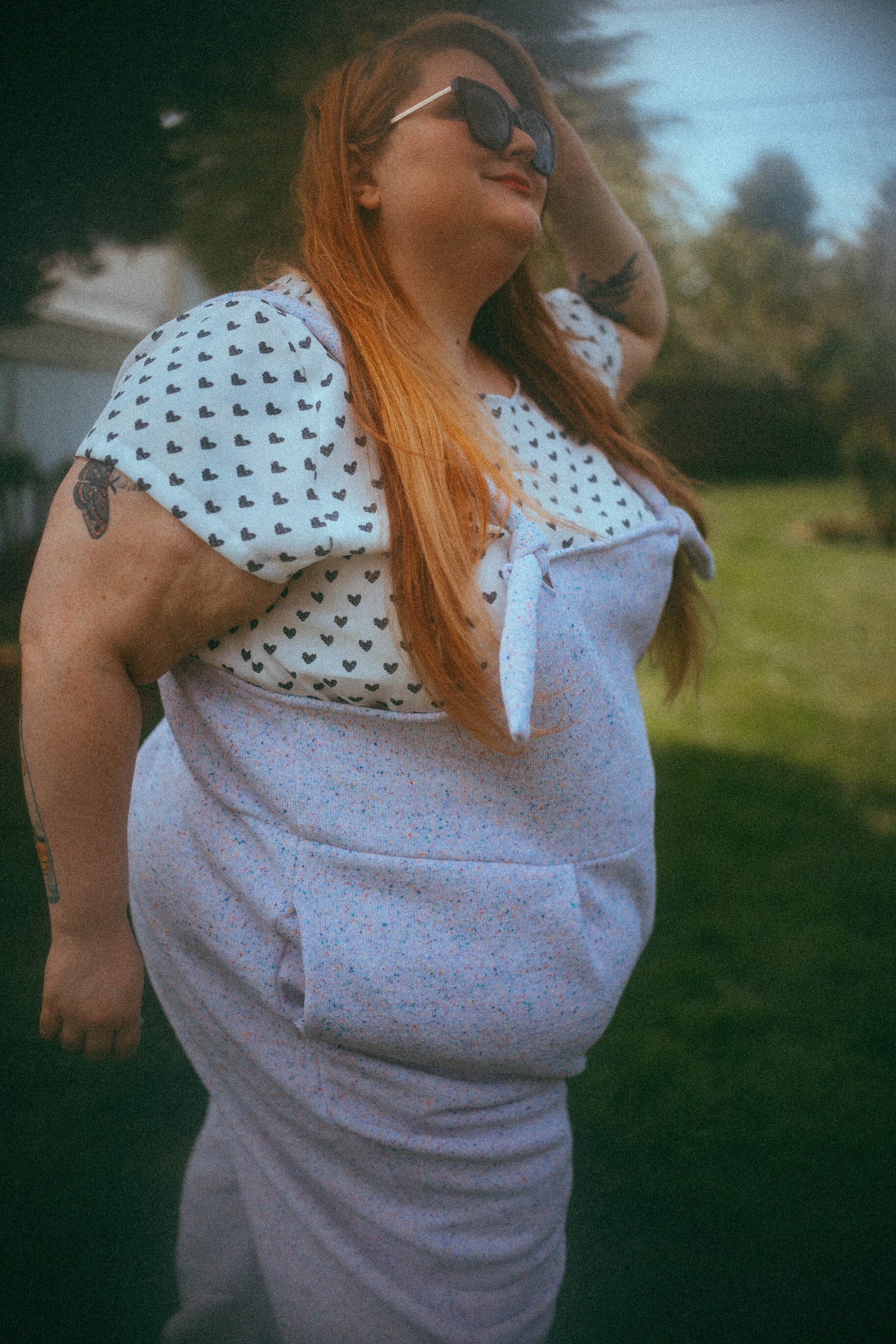 White scoop neck crop top with short sleeves and all over black heart pattern.